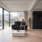 Person entspannt auf dem 2-Sitzer Relaxsofa Selesta Schwarz